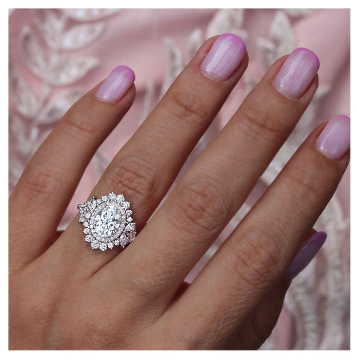 a close up of a person's hand with a diamond ring on her finger