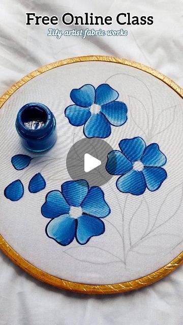 a blue flower on a white plate with gold trimmings and a small cup