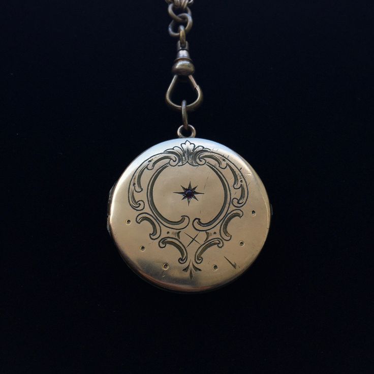 This regal turn of the century gold-filled European locket features a central engraved starburst design with a red paste stone surrounded by an artistic engraving. Although you might notice a few dings in this locket, they don't detract from its overall beauty. Bonus: this lovely locket has been paired with a Victorian-era gold-filled belcher chain that terminates in a fob clasp that could be used with ANY other pendant or locket. Snaps securely. Ornate Engraved Medallion Locket Necklace, Antique Silver Locket Necklace, Antique Silver Victorian Locket Necklace, Victorian Medallion Locket Necklace With Vintage Charm, Heirloom Antique Gold Locket Necklace With Antique Finish, Ornate Engraved Locket Necklace For Formal Occasions, Ornate Engraved Locket Necklace For Formal Events, Heirloom Antique Gold Locket Necklace, Antique Medallion Jewelry With Historical Design