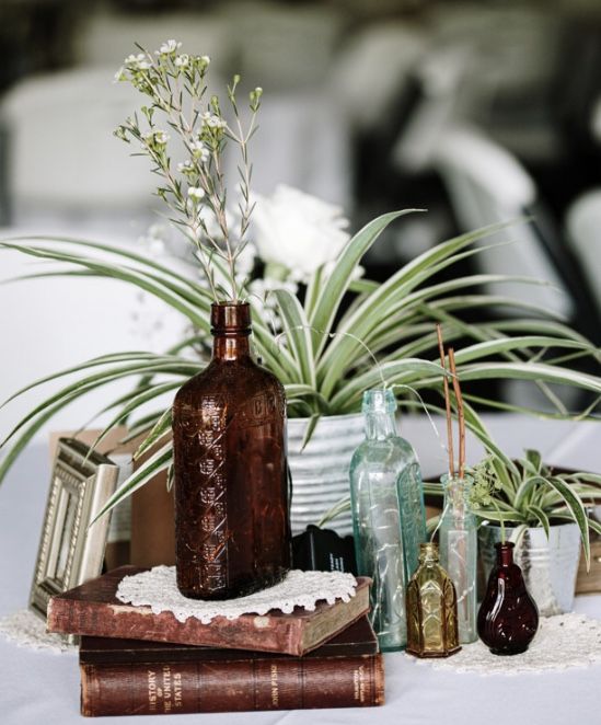 there are many bottles and plants on the table