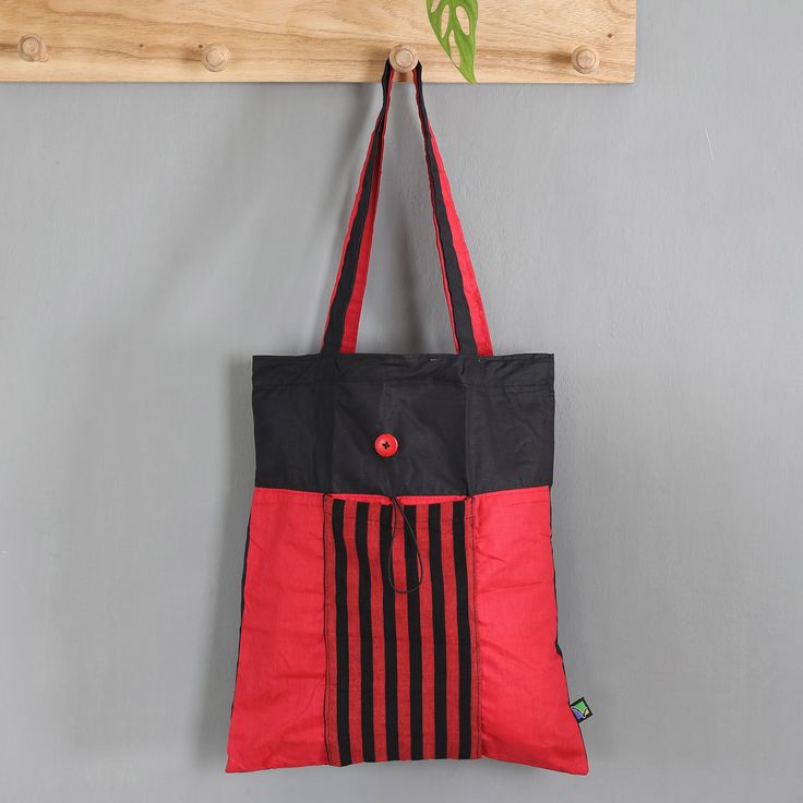 While this red and black tote bag is spacious enough for carrying your shopping bags or your travel essentials, it can also be folded to the size of a clutch bag for storage purposes. Handy reasons aside, the bag is hand-woven from cotton by the Lawe Lurik Community in Java, featuring a stylish aura thanks to its vibrant hues and the classic Indonesian lurik striped pattern on the exterior pocket, which comes with a button closure that allows for folding. Eco-friendly Red Tote Shoulder Bag, Red Eco-friendly Canvas Shopping Bag, Trendy Red Canvas Gift Bag, Eco-friendly Red Canvas Bag For Daily Use, Trendy Red Gift Bag, Black Foldable Bags For On-the-go, Black Eco-friendly Canvas Shoulder Bag, Eco-friendly Red Shoulder Bag For Shopping, Eco-friendly Red Tote Bag