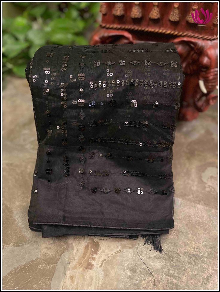 This designer net saree in black adorned with black sequins is exquisitely crafted to achieve a trendy look. Its lightweight net fabric will surely turn heads making it an ideal choice for any casual parties and date nights. The saree also comes with an unstitched raw silk blouse piece. It offers a unique and trendy look. Tassels on pallu adds charm to the saree.Perfect when paired with halter blouses and fusion jewelry, this statement-piece is a must-have in any wardrobe. Fall and pico - done B Party Pre-draped Saree With Mirror Work In Net, Black Georgette Pre-draped Saree With Resham Embroidery, Black Pre-draped Saree With Resham Embroidery, Festive Black Pre-draped Saree With Self Design, Black Pre-draped Saree For Festivals With Unstitched Blouse, Evening Chanderi Blouse Piece With Mirror Work, Evening Sequin Saree Fabric With Mirror Work, Evening Sequin Fabric With Mirror Work For Saree, Black Sequined Pre-draped Saree