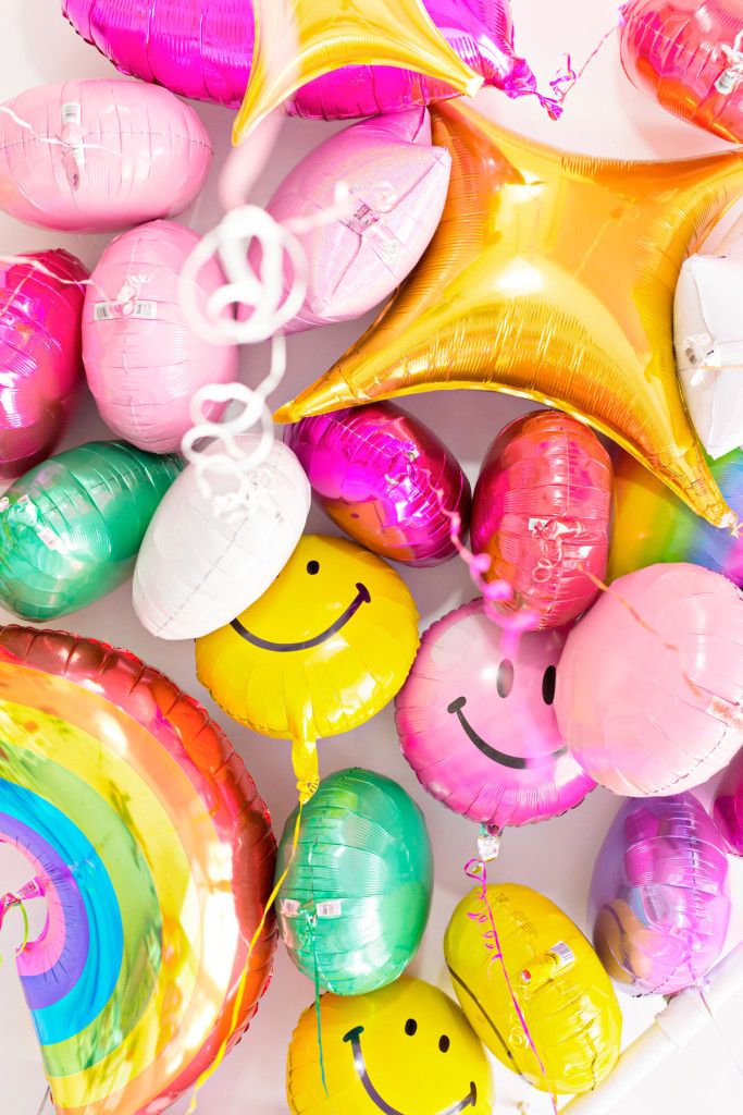 colorful balloons with smiley faces and rainbow colors are arranged in the shape of hearts, stars, and a star