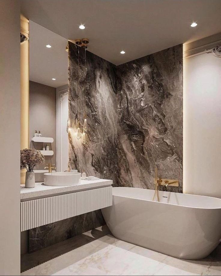 a bathroom with marble walls and flooring, white bathtub next to sink and mirror