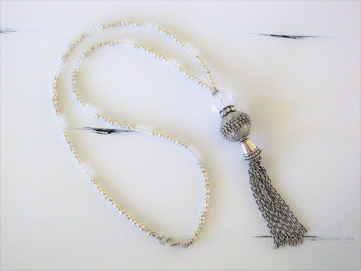 "Four different styles of silver beaded tassel necklaces to choose from, designed and handmade by Ralston Originals. I made all the tassels with silver chains, and covered each in a beautiful antique silver metal bead cap. The first beaded necklace (Pictures 1-3), is made with a very unique and beautiful large silver bead, with many tiny crystal inlaid accents. The necklace is also made with a large antique silver crystal roundel, and a large clear crystal bead. The beaded chain on the necklace Adjustable Beaded Chain Tassel Necklace As Gift, White Beaded Necklaces With Tassels For Gift, White Beaded Necklaces With Tassels As Gift, White Beaded Tassel Necklaces As Gift, Adjustable Tassel Necklace With Dangling Beads As Gift, Adjustable Tassel Necklace With Dangling Beads For Gift, Elegant Handmade Tassel Necklace With Round Beads, White Long Tassel Necklace As Gift, Lariat Beaded Necklace With Tassels For Gift