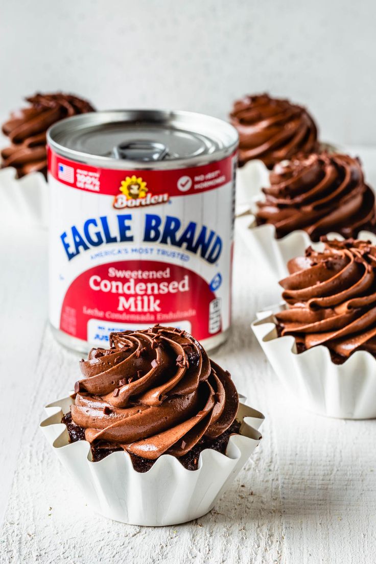 cupcakes with chocolate frosting and a can of eagle brand milk on the side