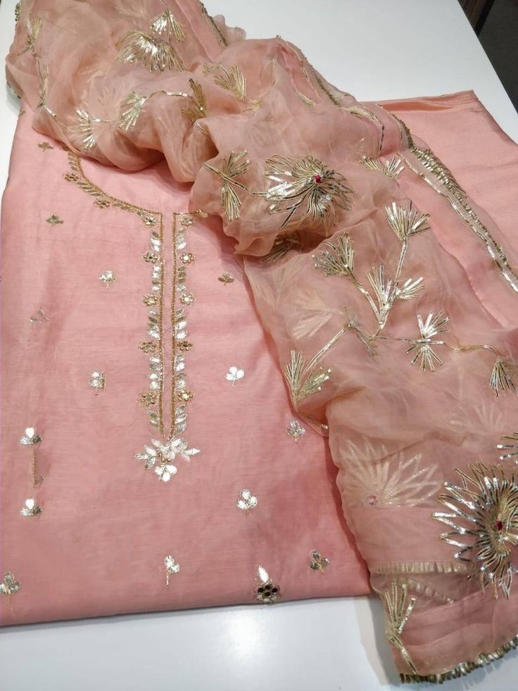 Item Overview ATHARVA Hand Embroidered Salwar Kameez * Beautiful Hand Embroidered Salwar Kameez * Beautiful Embroidered Neck /Jaal in Pink. * Beautiful Gota Pati Work Dupatta Fabric: * Shirt Chanderi Silk 2.5 Mts, * Dupatta: Pure Chiffon Chinnon 2.5 Mts (W/Gota Work Jaal) * Bottom Santoon 2.5 Mts. Excusive Hand Embroidered Party Wear Punjabi Suit. Customization: * Fabrics: Designs Can be made in different Fabrics. * Stitching Available Care: *Dry Clean/ Avoid direct Ironing on Embroidery Part. * Diwali Tissue Silk Churidar With Straight Kurta, Eid Traditional Wear With Gota Work On Tissue Silk, Tissue Silk Straight Kurta With Mirror Work, Pink Tissue Silk Kurta With Mirror Work, Straight Kurta With Gota Work In Dola Silk, Transitional Semi-stitched Kurta With Gota Work, Festive Tissue Silk Kurta With Embroidery, Chanderi Churidar With Mirror Work, Chanderi Churidar With Gota Work For Transitional Season