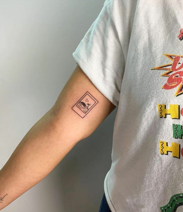 a person with a tattoo on their arm that has letters and numbers painted on it