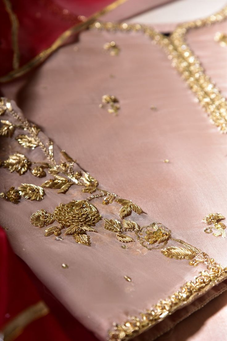 a pink dress with gold embroidered details on it