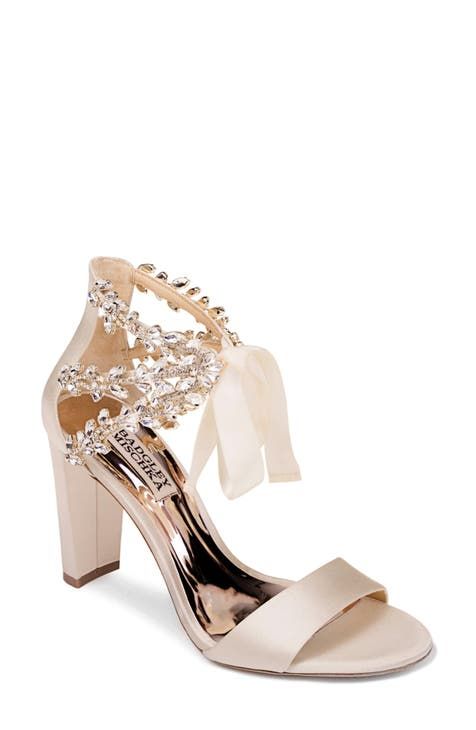 a women's white high heeled sandal with bows and pearls on the side