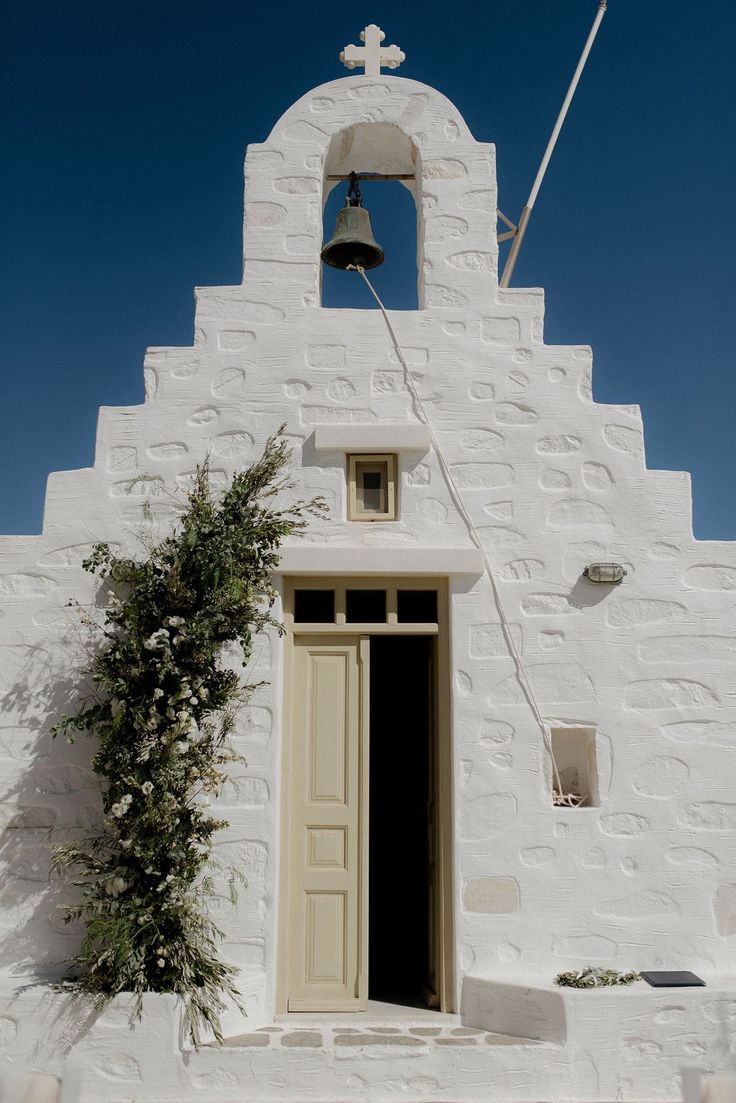 White wedding chapel in Paros, Greece at destination wedding with green and white flower arrangements Greek Chapel Wedding, Wedding Greek Style, Small Greek Wedding, Greek Wedding Flowers, Antiparos Wedding, Greek Wedding Aesthetic, Greece Wedding Aesthetic, Green And White Flower Arrangements, Intimate White