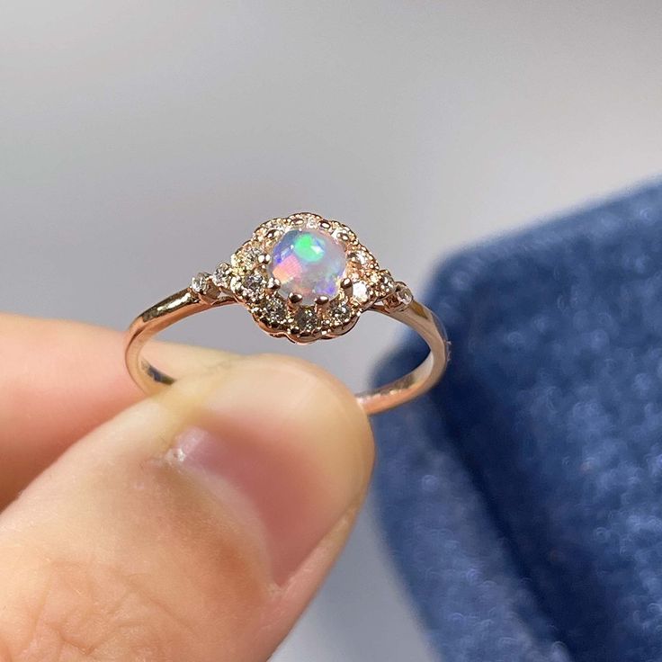 BASIC OPAL INFORMATION Round Opal : 5*5mm. Main stone: Natural good fire opal. Side stone: dainty cz diamond (cubic zircon). Material: 925 Sterling Silver +Natural opal stone. Metal color: silver, gold, rose gold. Metal materials: 925 sterling silver, 18K rose gold Plated, 18K rose gold Plated. SIMPLE DESIGN AND GOOD FIRE Delicate opal ring, that is perfect for stacking or wearing alone. A true beauty and must have! Sweet, simple, and dainty ring. Perfect for a minimalist look. They range from a Gold Round Cut Opal Ring, Opal Halo Jewelry As Gift, Gold Opal Ring With Halo Design, Ethiopian Opal Gemstone Jewelry For Weddings, Ethiopian Opal Ring For Wedding, Dazzling Opal Gemstone Ring Gift, Opal Ring With Cubic Zirconia And Halo Setting, Gift Opal Ring With Halo Design, Opal Ring With Halo Design As A Gift