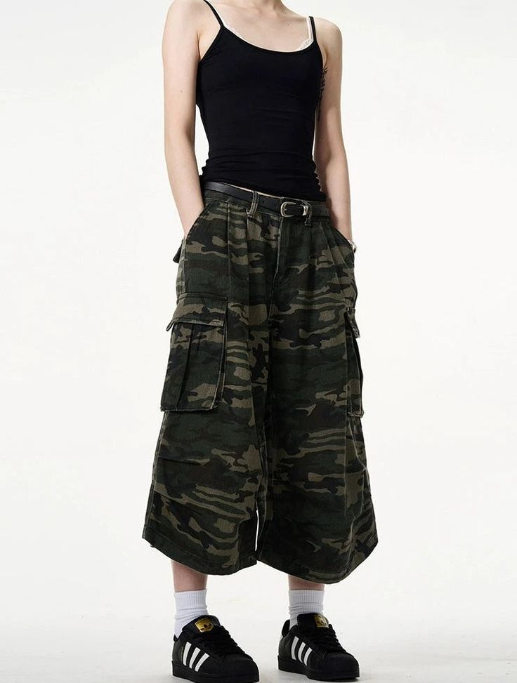 Embrace a fierce combination of style and practicality with our Camo Bermuda Capri Cargo Shorts. These high-waisted shorts feature a classic camouflage print, expertly crafted from a durable blend of materials for lasting comfort. The loose fit promotes freedom of movement while the integrated belt adds a functional, fashionable touch. Pair with a simple tee and sneakers for a laid-back look, or dress them up with a sleek blouse and ankle boots for a more sophisticated angle. Perfect for a varie Summer Combat Cotton Bottoms, Military Style Bottoms With Hip Pockets For Streetwear, Summer Military Pants With Cargo Pockets, High-waisted Utility Cargo Shorts, Summer Military Baggy Cargo Pants, Summer Military Style Baggy Cargo Pants, Baggy Military Cargo Pants For Summer, Summer Combat Cargo Bottoms, Summer Military Cargo Style Bottoms