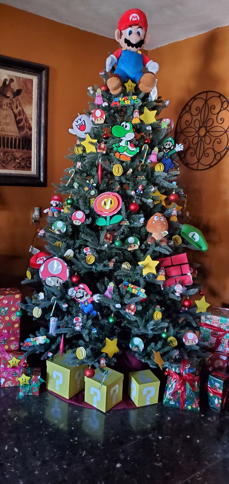 a nintendo themed christmas tree with mario and luigi on top, surrounded by presents under the tree