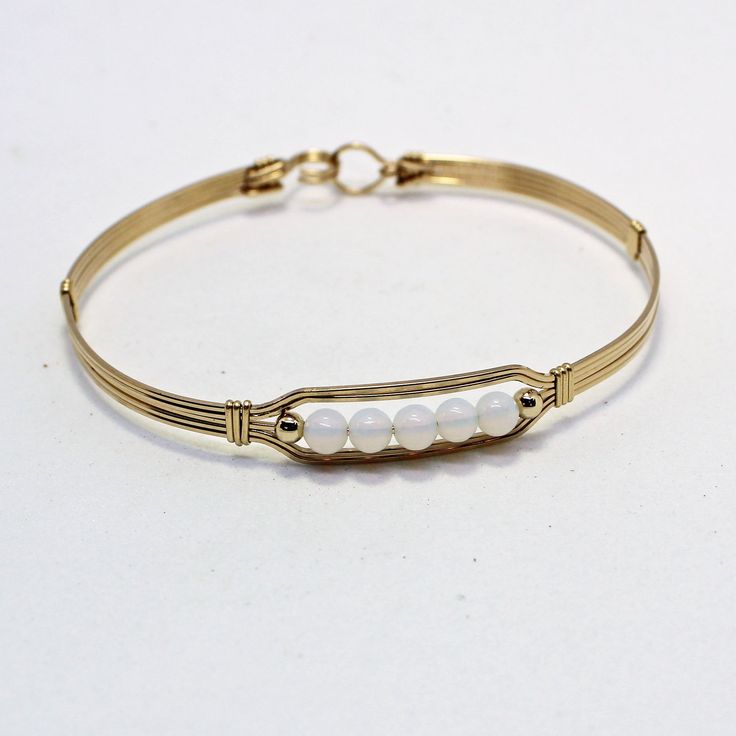 A contemporary little bracelet consisting of five strands of 14kt gold filled wire with a center design featuring five 4mm smooth glowing opalite beads and accented with two smaller 14kt gold filled beads. This sweet bracelet is stylish and simple, and it's stackable with most of my other wirewrapped bracelet styles! The opalite shifts from white to blue to lavender overtones, depending on what you wear it with, making it the perfect accessory for every outfit! The sturdy built-in hook and eye c Bracelet Styles, Bracelet Bead, Bead Bangles, Gold Bangle Bracelet, Gold Bangle, Wire Bracelet, Gold Wire, Bracelet Gold, Wire Wrap