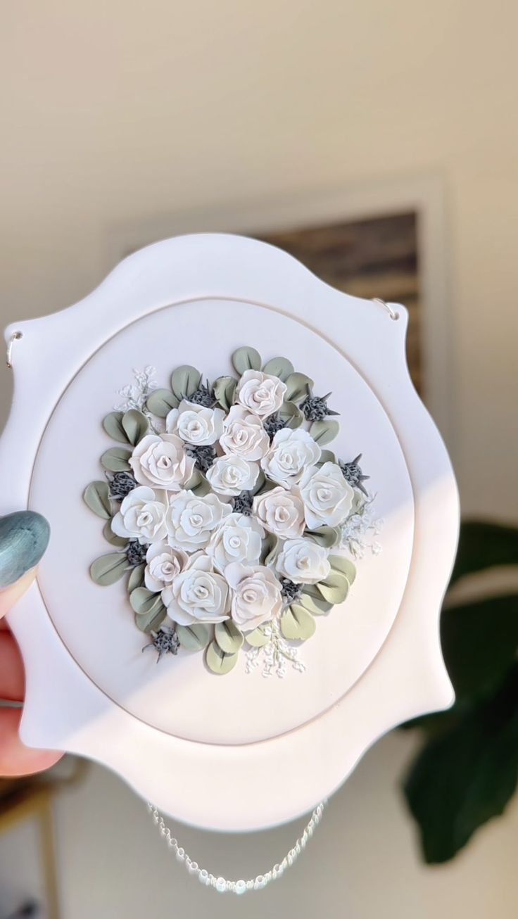 a person holding a white plate with flowers on it