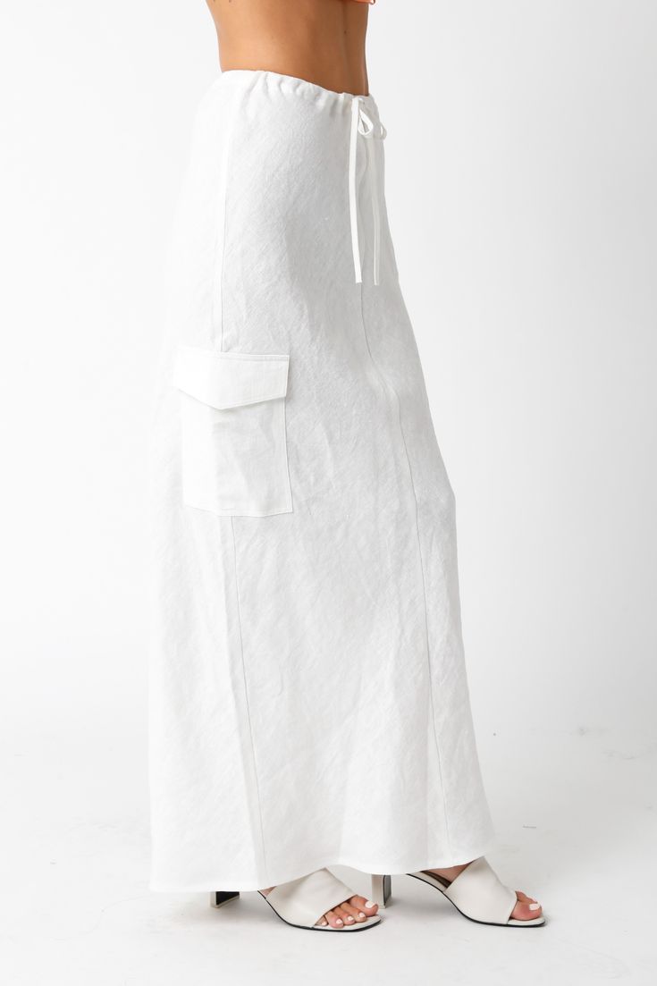 The Kaia White Linen Cargo Maxi Skirt is the perfect vacation cover-up! White linen woven fabric shapes this cargo maxi skirt with a mid-rise fit and drawstring tie. Style with sandals and a cute top and wear to dinner! DETAILS & FIT Loose Fit. 100% Linen. Machine wash cold. Imported.