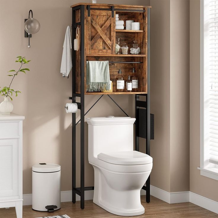 a white toilet sitting next to a wooden cabinet in a bathroom on top of a hard wood floor