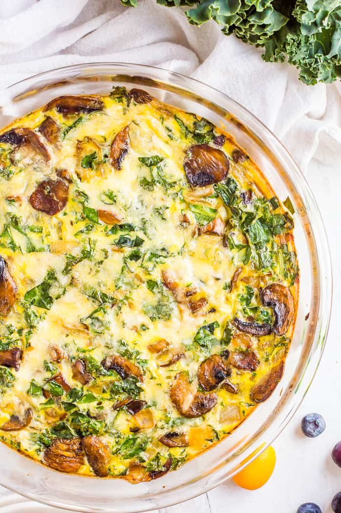 an overhead view of a casserole dish with cheese, spinach and mushrooms