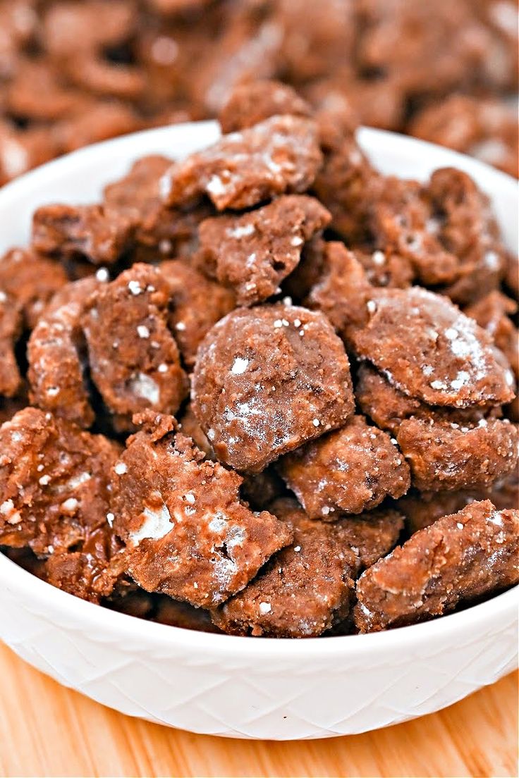 a white bowl filled with chocolate cookies on top of a wooden table