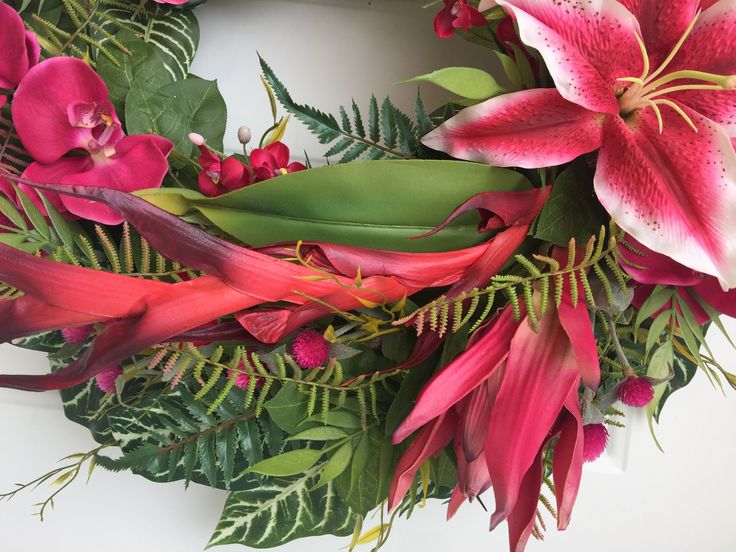 a wreath with pink flowers and green leaves