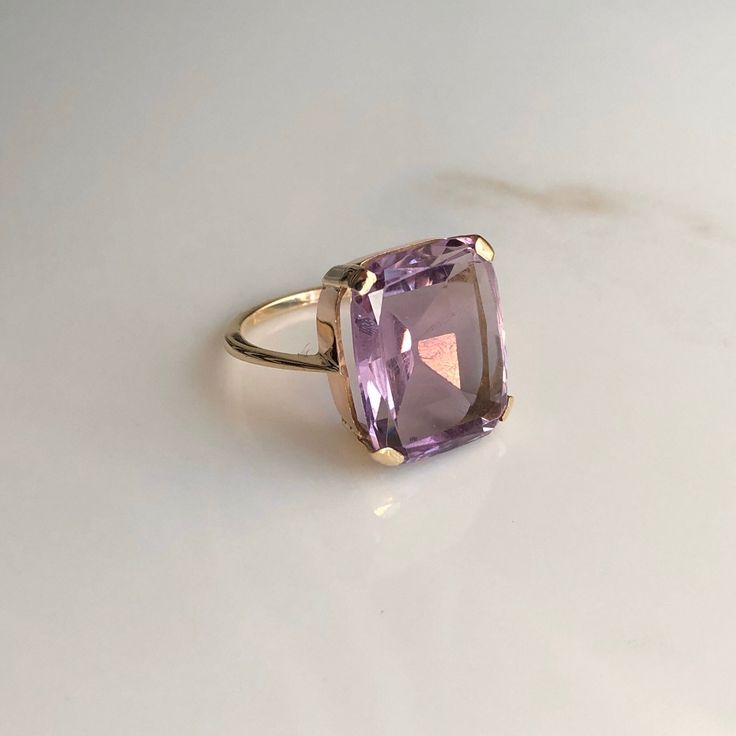 A 9 carat yellow gold Amethyst ring. This beautiful piece displays a gorgeous purple stone in the clutches of a striking gold setting. CONDITION: Minor wear can be seen on face. Condition consistent with age and use. Please see photos for more detail. STONE SIZE: 13mm x 15mm BAND WIDTH: 1mm SETTING HEIGHT: 5mm RING SIZE: UK: M | US: 6 1/4 WEIGHT: 4.2 grams Luxury Yellow Gold Amethyst Ring, Luxury Vintage Amethyst Ring, Luxury Yellow Gold Amethyst Ring With Accent Stones, Elegant Lavender Amethyst Ring In 14k Gold, Formal 14k Gold Amethyst Ring, Luxury Purple Amethyst Ring For Formal Occasions, Classic Yellow Gold Rectangular Amethyst Ring, Rectangular Amethyst Ring For Formal Occasions, Rectangular Amethyst Ring For Formal Events