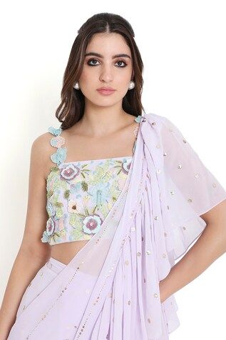 Lavender pre-draped mukaish work ruffled saree. Paired with a floral applique work blouse. - Aza Fashions Fitted Sleeveless Saree With Ruffles, Spring Wedding Georgette Top, Summer Wedding Saree With Ruffles, Summer Wedding Pre-draped Saree With Ruffles, Summer Wedding Pre-draped Ruffled Saree, Fitted Blouse With Ruffles And Traditional Drape, Fitted Ruffled Blouse With Traditional Drape, Fitted Draped Blouse With Ruffles, Fitted Blouse With Cape Sleeves For Reception