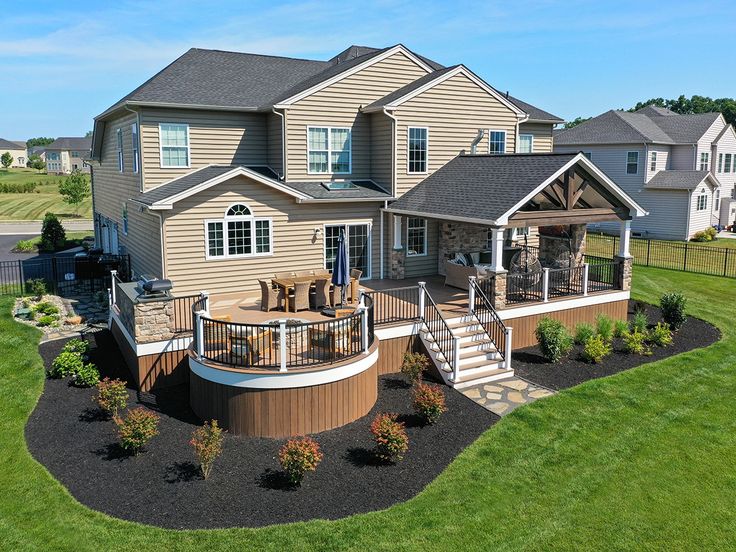 an aerial view of a large house with deck and hot tub in the front yard