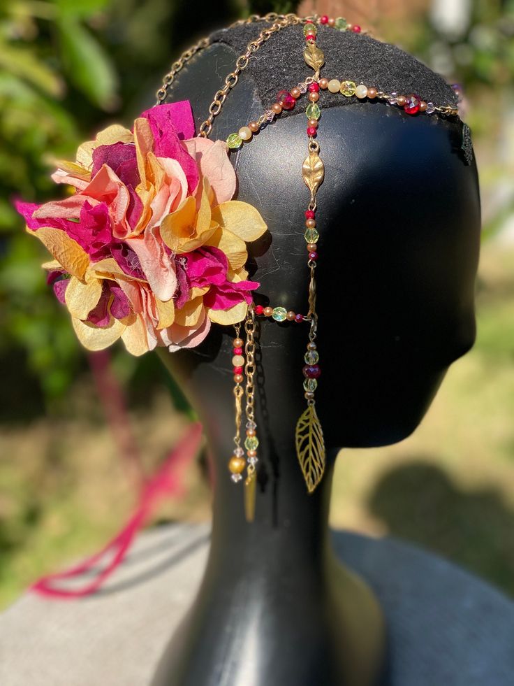 Gorgeous headpiece in warm pinks and golds. Delicate flowers, semiprecious beads and up-cycled jewelry. Perfect for festival, dance and fantasy costuming. Can be worn as a belt as well as a headdress or even a neck piece! Created with dancing in mind each piece comes with matching clips for securing in place. Fantasy Headpieces For Mardi Gras, Adjustable, Bohemian Headpiece For Mardi Gras Party, Adjustable Fantasy Headpieces For Carnival, Fantasy Adjustable Headpieces For Carnival, Bohemian Headpiece For Carnival, Festival Beaded Headband, Bohemian Carnival Headband, Beaded Festival Headband, Whimsical Adjustable Headpieces For Carnival