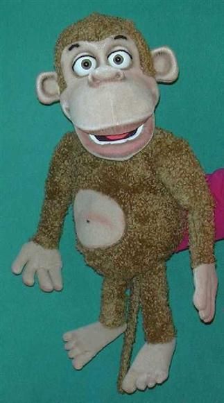 a stuffed monkey sitting on top of a green surface