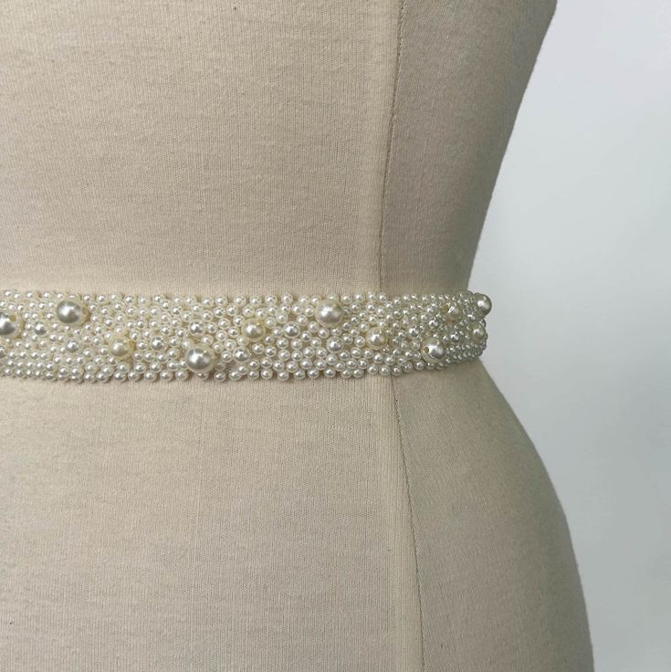 A beautiful pearl-embellished belt, that sits at the waistline of your bridal gown or skirt and adds a little something special to your bridal look. Perfect to wear with a plain dress that you wish to accessorise. The pearl beads cover the entire tulle band which fastens with a concealed closure at the back. Our belts are made-to-order, so please send us your waist measurement in inches when purchasing and we will make it to your correct size. Embellish your wedding look with any of our Oscar Li Pearl Belt For Wedding Dress, Elegant Beaded Bridal Belt, Elegant Beaded Fitted Bridal Belt, Wedding Bridal Belt Beaded With Pearls, Wedding Bridal Belt With Beaded Pearls, Wedding Pearl Beaded Bridal Belt, Elegant White Bridal Belt With Pearl Embroidery, Elegant Pearl Embellished Bridal Belt For Wedding, Elegant Pearl Embellished Bridal Belt