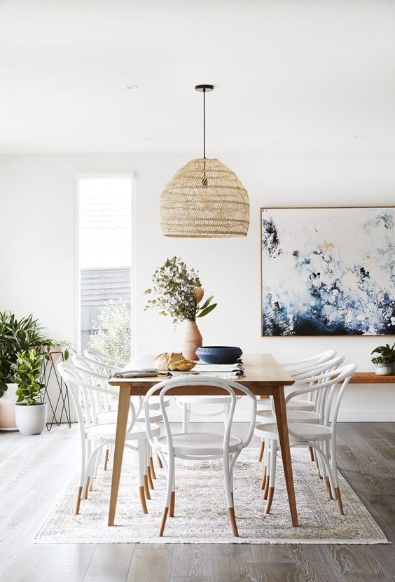 a dining room table with chairs and plants