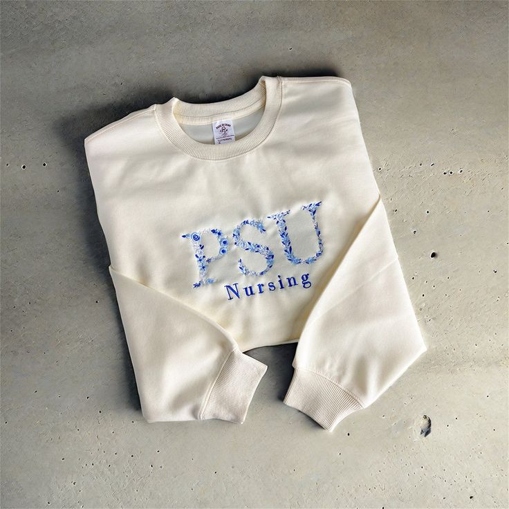 Introducing our personalized embroidered sweatshirt, the perfect choice for a thoughtful and unique gift for anyone on your list! Whether it's for a recent grad, a sports enthusiast, or a beloved family member, this customizable sweatshirt allows you to add a personal touch to the front with text of your choice. Product Features: Made from a cozy blend of 50% cotton and 50% polyester, ensuring comfort and durability. Classic crewneck design for a timeless look and feel. Available in a variety of White Fleece Sweatshirt With Embroidered Logo, White Collegiate Sweatshirt With Custom Embroidery, White Sweatshirt With Custom Embroidery, Relaxed Fit, White Sweatshirt With Custom Embroidery In Relaxed Fit, White Embroidered Fleece Top, White Fleece Top With Embroidered Graphics, Cream Embroidered Crew Neck Sweatshirt, White Cotton Sweater With Letter Embroidery, Cream Cotton Sweatshirt With Embroidered Logo