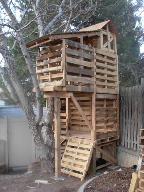 a tree house made out of wooden pallets