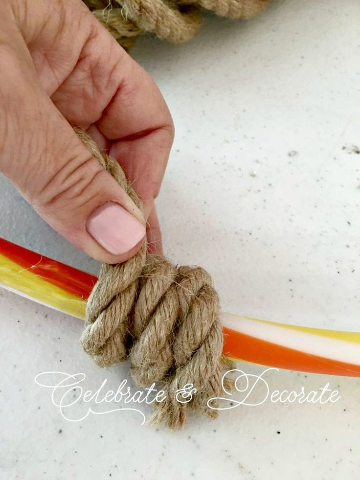 a person tying a rope with two different colored ropes next to each other on a table