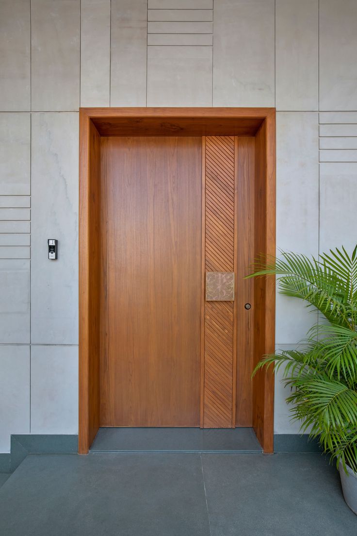 a large wooden door sitting next to a potted plant