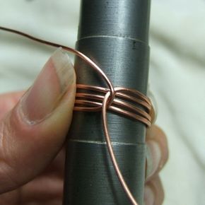 a person is holding a piece of wire in their left hand and the end of it wrapped in copper