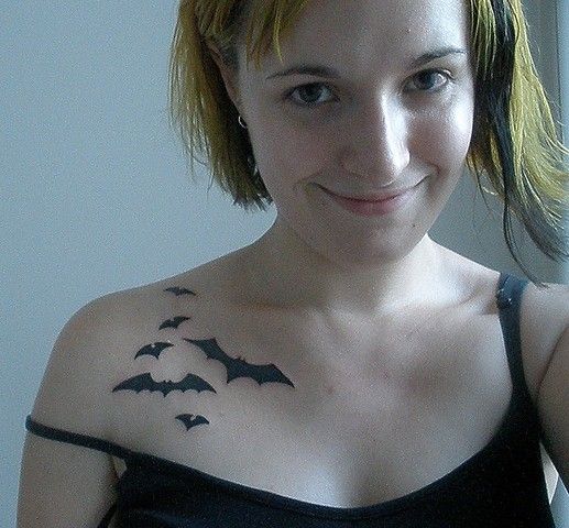 a woman with bats tattooed on her chest