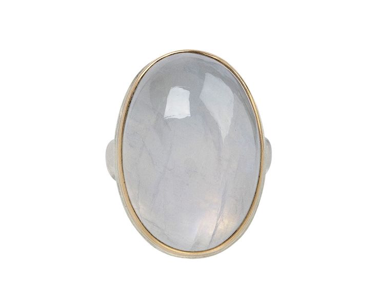 Shimmering with a milky white landscape of subtle iridescence, this Jamie Joseph ring exudes a quiet, elegant beauty. The large oval stone is framed by a band of 14K yellow gold. It is centered on Jamie's signature sterling silver groovy band to create a ring with a cool, casual vibe. Moonstone is known for its gorgeous pearly luster and is believed to release tension, balance emotions and bring light to ones life. white rainbow moonstone : 27mm x 18mmsterling silver groovy band width : 5mm size Luxury White Oval Moonstone Ring, Modern Oval Cabochon Moonstone Ring, Luxury Polished Oval Cabochon Moonstone Ring, Luxury Polished Moonstone Ring With Oval Cabochon, Luxury Oval Cabochon Moonstone Ring With Polished Finish, Modern Oval Moonstone Ring With Large Stone, White Cabochon Moonstone Ring For Formal Occasions, Luxury Oval Moonstone Ring For Formal Occasions, Luxury Formal Oval Moonstone Ring