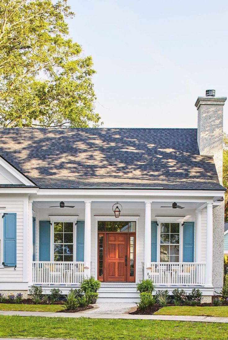 a white house with blue shutters and a red door