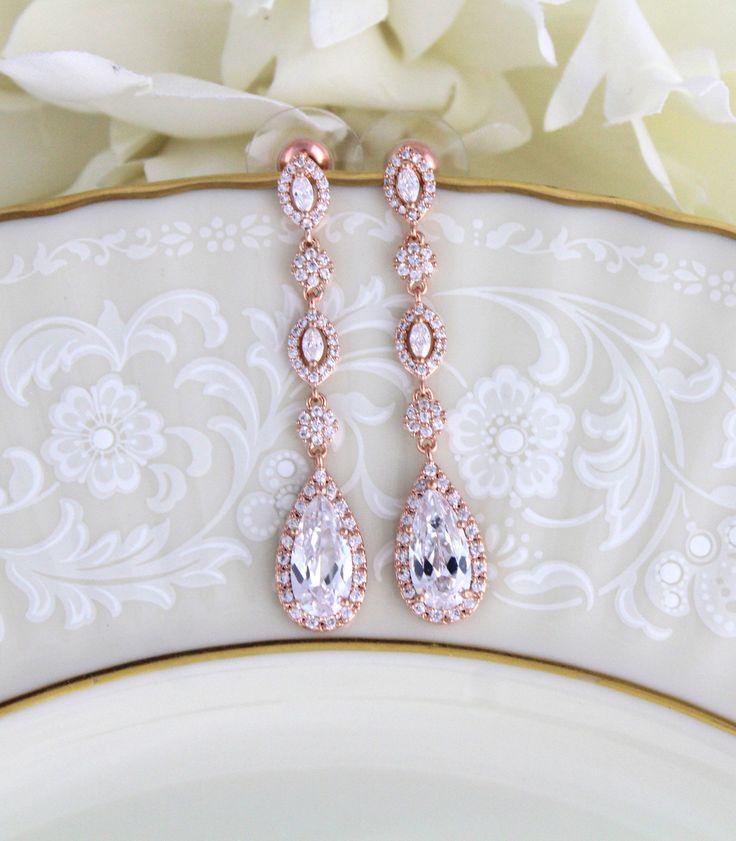 "Lovely and delicate long bridal earrings created with Swarovski Pure Brilliance stones. Perfect for a bride or bridesmaid. Earrings measure 1-3/4\" x 3/8\" Available in rose gold, yellow gold and rhodium finish. Matching pieces: https://www.etsy.com/listing/504956816/dainty-backdrop-necklace-rose-gold-back?ref=shop_home_active_1 https://www.etsy.com/listing/489105735/crystal-bridal-bracelet-rose-gold?ref=shop_home_active_1 https://www.etsy.com/listing/674474135/rose-gold-bridal-bracelet-teardro Rose Gold Cubic Zirconia Drop Bridal Earrings, Rose Gold Cubic Zirconia Bridal Earrings For Wedding, Rose Gold Cubic Zirconia Dangle Bridal Earrings, Elegant Rose Gold Teardrop Earrings For Wedding, Rose Gold Drop Crystal Earrings For Wedding, Rose Gold Long Drop Earrings For Wedding, Wedding Long Drop Linear Earrings In Cubic Zirconia, Crystal Linear Earrings For Wedding, Elegant Rose Gold Chandelier Earrings For Weddings