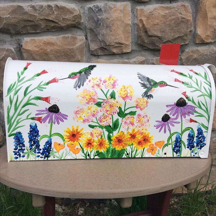 a painted mailbox sitting on top of a wooden table