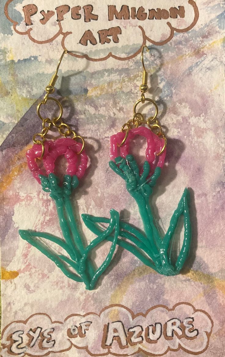 two pink flowers are hanging from gold earwires on a card with the words, eye of azure