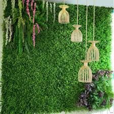 an artificial green wall with hanging birdcages