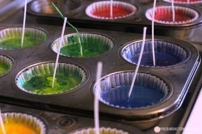 cupcake tins filled with green and red icing sitting on top of a stove