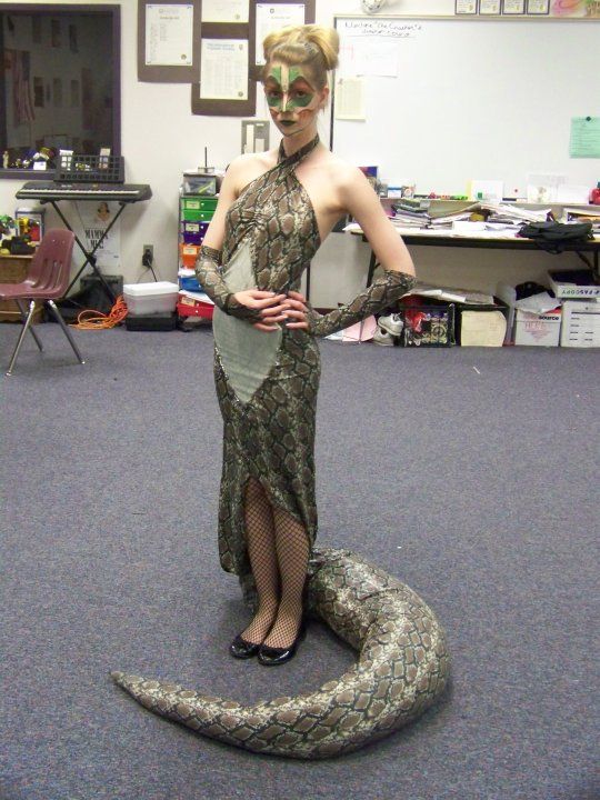 a woman is dressed up as a snake in an office setting with her hands on her hips