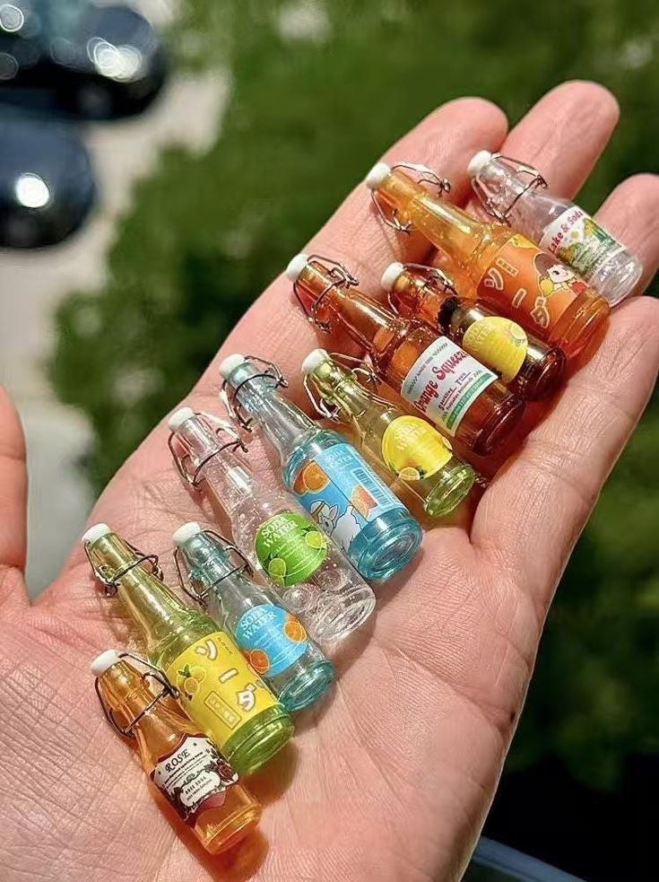 a person holding several small bottles in their palm