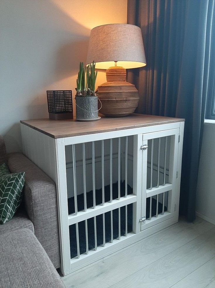 Cozy Den: A charming hideaway for your furry friend where they can relax and unwind in comfort and style. Storage On Top Of Dog Crate, Indoor Dog Crate Furniture, Hide Dog Kennel, Diy Dog Crate Desk, Aesthetic Dog Kennel, Dog Area In Living Room, Indoor Dog Area Ideas, Homemade Dog Crate, Pet Room Ideas Cats