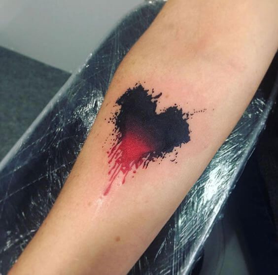 a black and red ink splattered on the left arm, with a heart in it