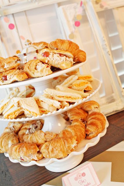 three tiered trays filled with pastries on top of a table next to cards